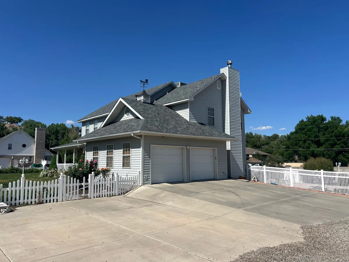 Home with a gray shingle roof over the main house and attached garage