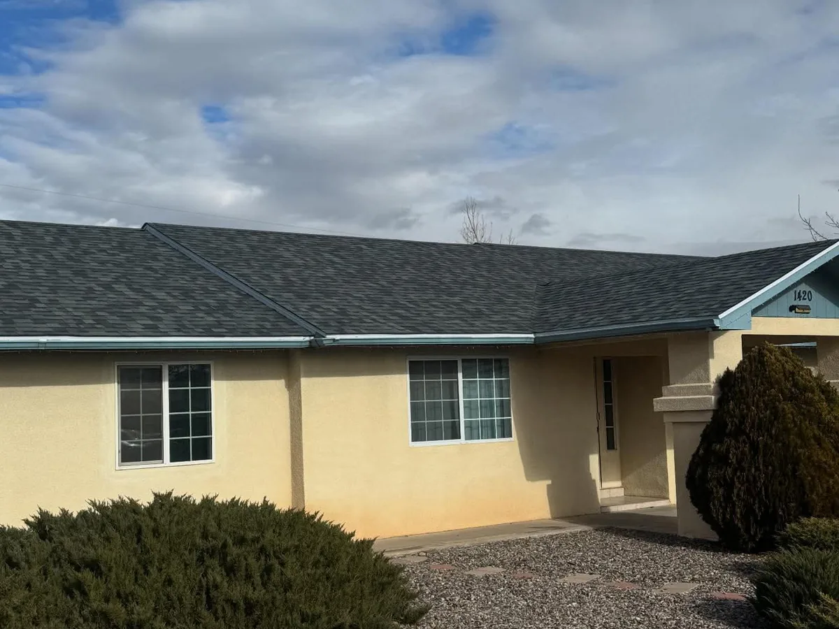 Stucco home with a newly installed gray shingle roof