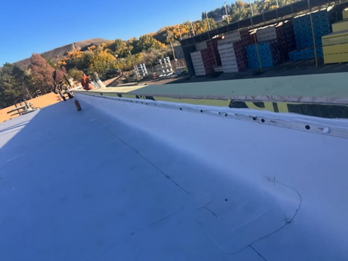 White single ply flat roof membrane with a fastened seam along the edge